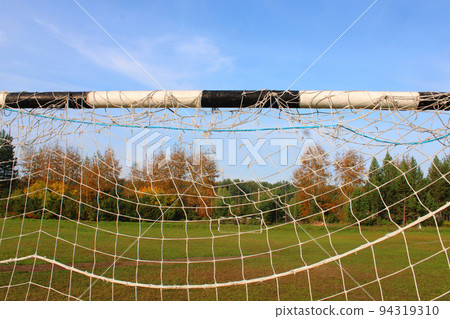 Old football goal against the background of the football field and autumn forest Old football goal against the background of the football field and autumn forest 94319310