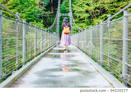 A woman crossing a suspension bridge, Tenryukyo Suspension Bridge (Tsutsuji Bridge) 94320577