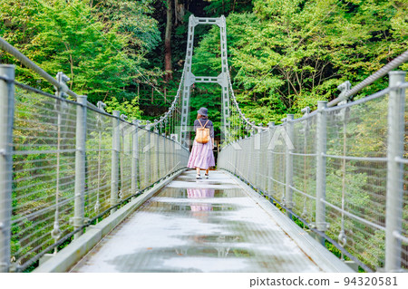 A woman crossing a suspension bridge, Tenryukyo Suspension Bridge (Tsutsuji Bridge) A woman crossing a suspension bridge, Tenryukyo Suspension Bridge (Tsutsuji Bridge) 94320581