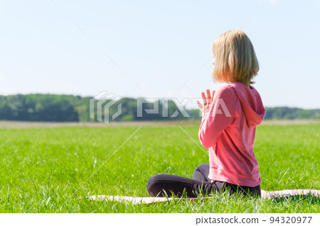 Woman doing yoga in the park 94320977