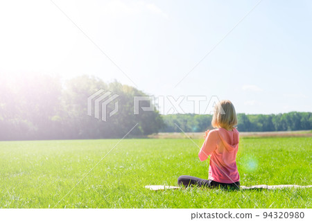 Woman doing yoga in the park Woman doing yoga in the park 94320980