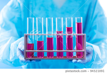 Lab assistant uniform with mask gloves holding test tube with science laboratory research sample while analyzing development on biology chemical as graph growth increase investment revenue, copy space Lab assistant uniform with mask gloves holding test tube with science laboratory research sample while analyzing development on biology chemical as graph growth increase investment revenue, copy space 94321091