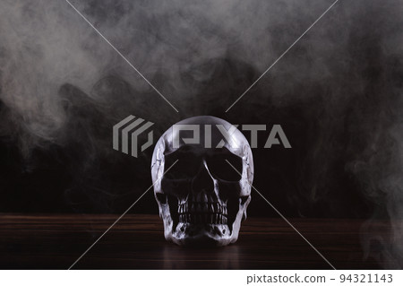 Halloween human skull on an old wooden table over black background. Shape of skull bone for Death head on halloween festival which show horror evil tooth fear and scary with fog smoke, copy space Halloween human skull on an old wooden table over black background. Shape of skull bone for Death head on halloween festival which show horror evil tooth fear and scary with fog smoke, copy space 94321143