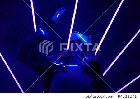Woman is using virtual reality headset to access in metaverse. 94321271