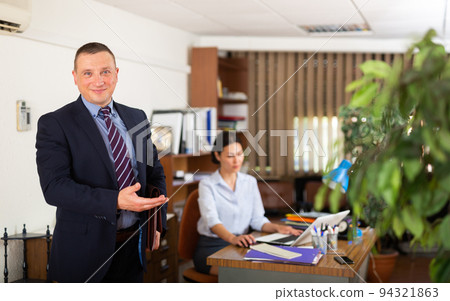 Portrait of successful businessman inviting to modern office Portrait of successful businessman inviting to modern office 94321863