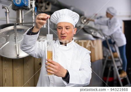 Brewery owner checking alcoholic content in beer with hydrometer Brewery owner checking alcoholic content in beer with hydrometer 94321988