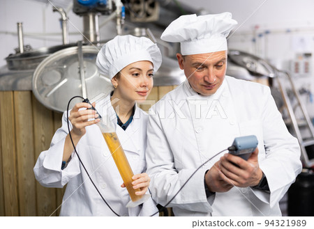 Male and female brewers measuring pH in beer with digital meter Male and female brewers measuring pH in beer with digital meter 94321989