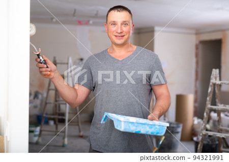 Man painting wall in apartment 94321991