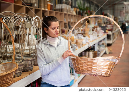 Woman looking for wickerwork in shop 94322033