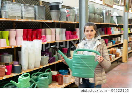 Woman choosing watering can Woman choosing watering can 94322105