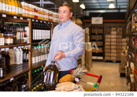 Male customer choosing olive oil Male customer choosing olive oil 94322166