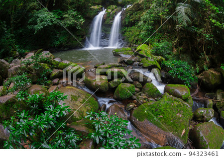 Beautiful woman in red dress in front of the Sapan Waterfall, Khun Nan National Park, Boklua District, Nan Province, Thailand. 94323461