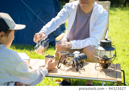 Pouring a drink into someone else's cup Pouring a drink into someone else's cup 94323827