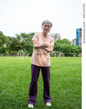 Portrait of mature asian woman 60s with sore wrist at park outdoor. 94324764