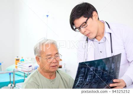 Asian elder adult having a consult with doctor about his disease, doctor explains the x-ray film to Asian senior adult. Health care and wellness in aging society. 94325252