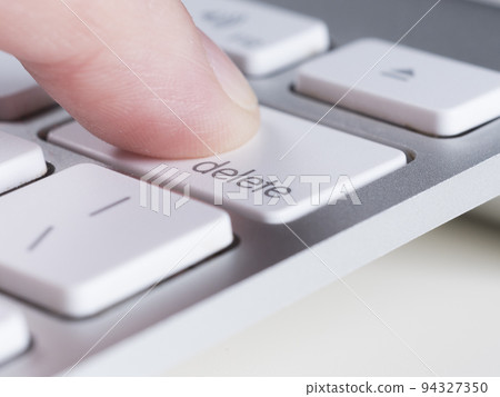 Finger is pressing delete key of computer keyboard 94327350