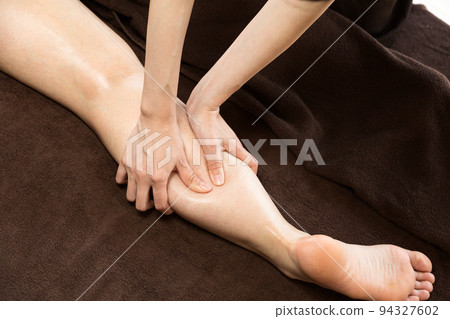 A woman is getting a calf massage. A woman is getting a calf massage. 94327602