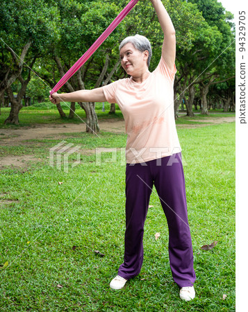 機場娛樂活動愉快，女士們在草地上微笑並使用動力腰帶鍛煉身體，並在公園內享受大自然的新鮮空氣。 94329705