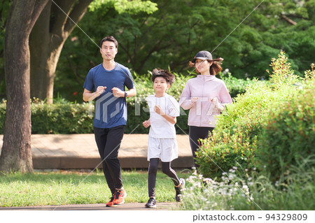 在公園裡奔跑的夫婦和孩子家庭形象 94329809