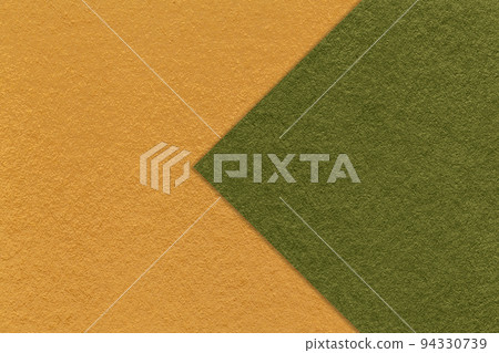 Texture of yellow paper background, half two colors with dark green arrow, macro. Craft olive cardboard. Texture of yellow paper background, half two colors with dark green arrow, macro. Craft olive cardboard. 94330739