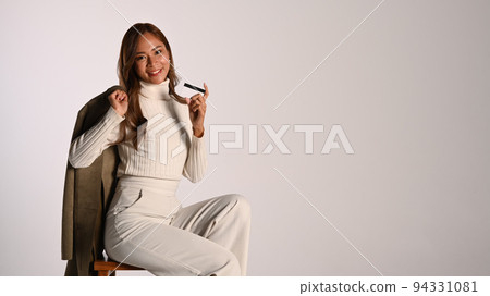 Stylish young woman with credit card sitting on light background. Autumn fashion, Black Friday, sale, shopping concept Stylish young woman with credit card sitting on light background. Autumn fashion, Black Friday, sale, shopping concept 94331081