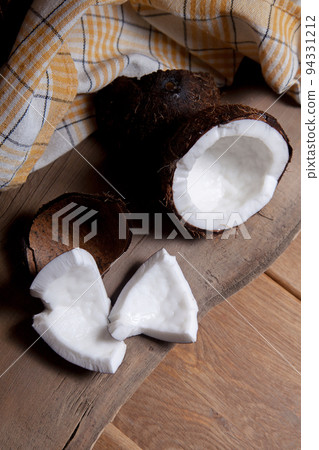 Coconut with white pulp on wooden background.. Coconut with white pulp on wooden background.. 94331212