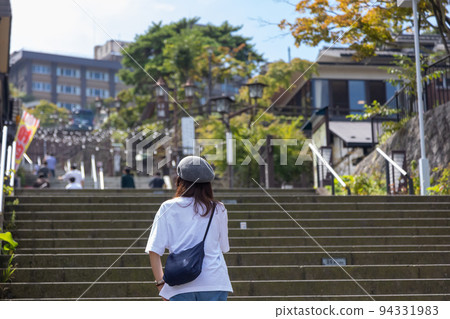 A woman walking along the stone steps of Ikaho Onsen A woman walking along the stone steps of Ikaho Onsen 94331983