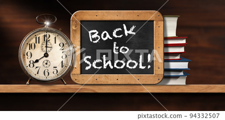 Back To School - Alarm Clock on Wooden Shelf with a Blackboard and Books 94332507