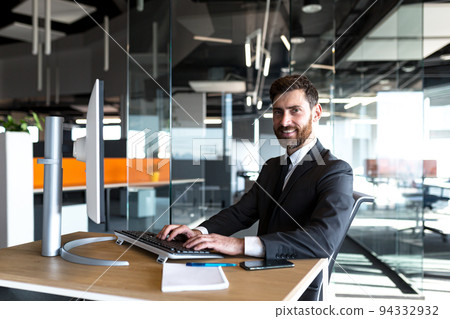 Successful businesswoman looking at camera and smiling happy boss working at computer in modern office Successful businesswoman looking at camera and smiling happy boss working at computer in modern office 94332932