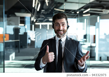 Male online consultant, smiling and looking at camera, providing customer support, smiling and rejoicing Male online consultant, smiling and looking at camera, providing customer support, smiling and rejoicing 94332973