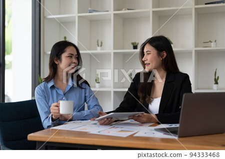 Two asian business woman workers smiling happy and confident. Working together with smile on face at the office Two asian business woman workers smiling happy and confident. Working together with smile on face at the office 94333468