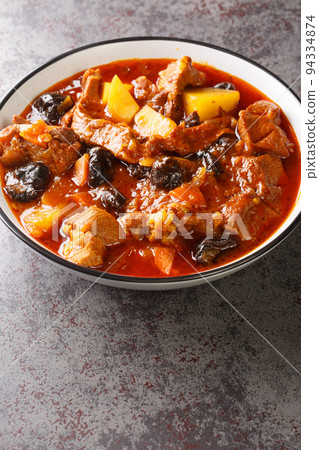 Persian Plum Stew Khoresht Aloo with lamb closeup in the bowl. Vertical 94334874