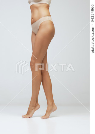 Legs and buttocks. Cropped image of female tanned body of young woman in underwear isolated on gray background. Wellness, weight loss, treatment, health care, fitness Legs and buttocks. Cropped image of female tanned body of young woman in underwear isolated on gray background. Wellness, weight loss, treatment, health care, fitness 94334966