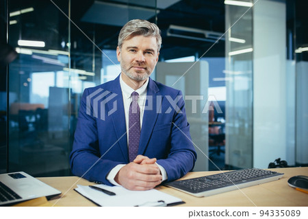 Portrait of successful seo boss, businessman at work, working on computer in modern office, looking at camera, happy and smiling 94335089