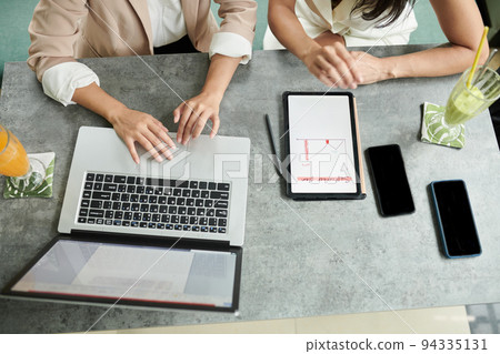 Cropped image of businesswoman sitting at cafe table and planning work for upcoming month Cropped image of businesswoman sitting at cafe table and planning work for upcoming month 94335131