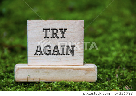 Try again text on wooden block with green nature background. Motivational concept Try again text on wooden block with green nature background. Motivational concept 94335788