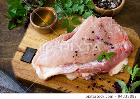 Fresh raw meat. Raw pork meat fillet with olive oil, spices and fresh basil on rustic wooden table. Fresh raw meat. Raw pork meat fillet with olive oil, spices and fresh basil on rustic wooden table. 94335882