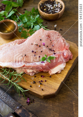 Fresh raw meat. Raw pork meat fillet with olive oil, spices and fresh basil on rustic wooden table. Fresh raw meat. Raw pork meat fillet with olive oil, spices and fresh basil on rustic wooden table. 94335883
