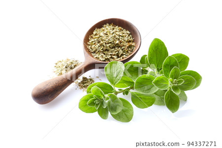 Marjoram twigs with dry marjoram in wooden spoon on white background Marjoram twigs with dry marjoram in wooden spoon on white background 94337271