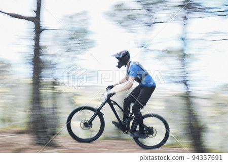 Teenager in forest practicing downhill biking. Teenager in forest practicing downhill biking. 94337691