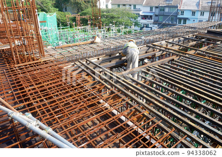 MELAKA, MALAYSIA -JULY 1, 2022: Construction workers are fabricating steel reinforcement bars for floor slabs. Rebar of various sizes is arranged and tied according to the design by the engineer. MELAKA, MALAYSIA -JULY 1, 2022: Construction workers are fabricating steel reinforcement bars for floor slabs. Rebar of various sizes is arranged and tied according to the design by the engineer. 94338062