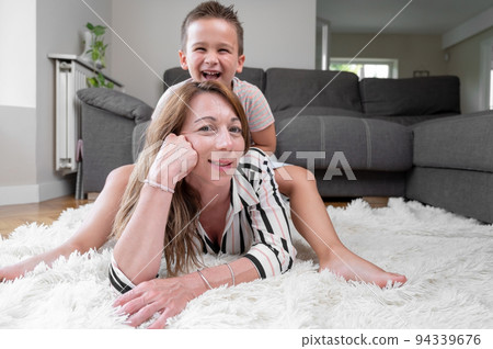 Excited naughty children riding on top of mom. Excited naughty children riding on top of mom. 94339676
