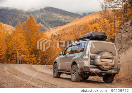 SUV on scenic autumn road in the forest 94339722