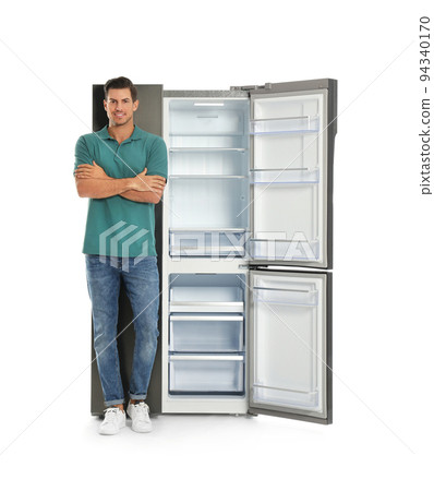 Man near open empty refrigerator on white background 94340170