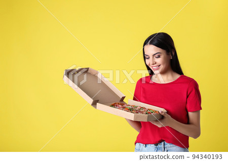Beautiful woman with tasty pizza on yellow background 94340193