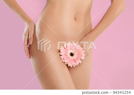Woman with flower showing smooth skin after bikini epilation on beige background, closeup Woman with flower showing smooth skin after bikini epilation on beige background, closeup 94341254