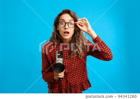 Beautiful young woman with vintage video camera on light blue background 94341260