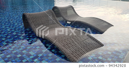 relax deck chair by the blue pool at swimming pool in luxury spa resort or villa Tourism industry crisis after covid 19 coronavirus pandemic Travel lifestyle on family summer vacation 94342928