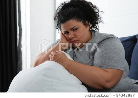 Overweight woman suffering from depression at home Overweight woman suffering from depression at home 94342987
