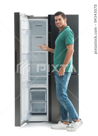 Man near empty refrigerator on white background 94343078
